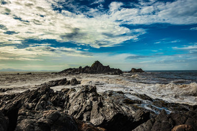 Rocky sea beach with crashing waves at morning from flat angle