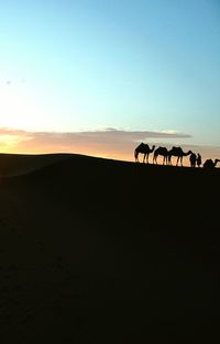 Silhouette of horse on landscape against clear sky