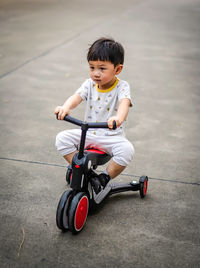 High angle view of boy playing with push scooter on floor