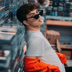 Side view of boy wearing sunglasses standing outdoors