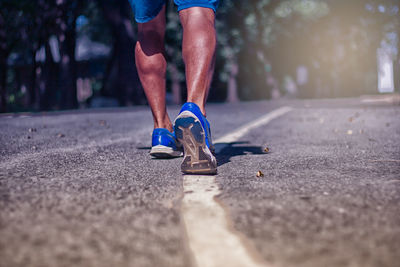 Low section of man running on road