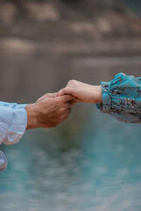 Cropped hands holding by lake