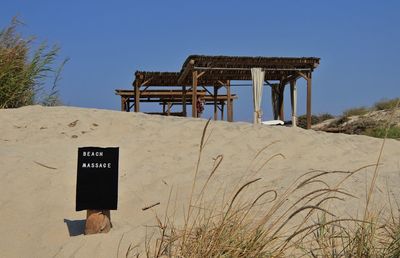 Built structure on beach against clear blue sky