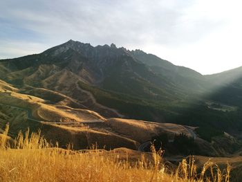 Scenic view of field and mountains against sky