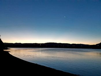 Scenic view of lake against blue sky during sunset