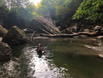 Man surfing on rock in lake