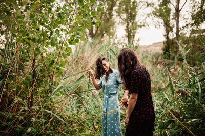 Women standing by plants in forest