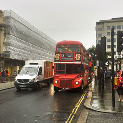 Cars on road in city against sky