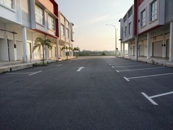 Empty road by buildings in city