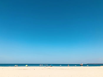 Scenic view of beach against clear blue sky