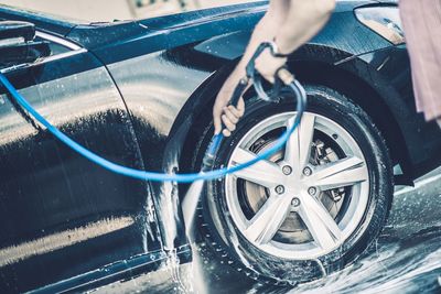 Midsection of person washing car