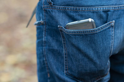 Cropped image of person with mobile phone in pocket