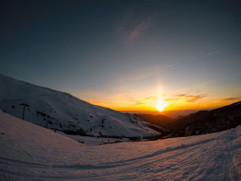 Scenic view of snow covered mountains against sky during sunset