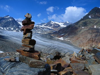 Stacked rocks against mountains during winter