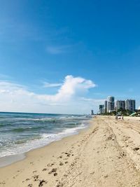 Scenic view of beach against blue sky