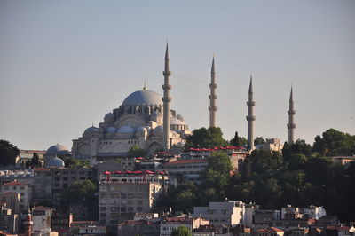 Buildings in city against clear sky