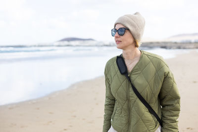 Portrait of young woman standing at beach