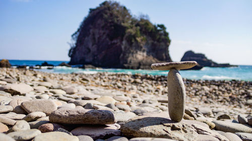 Surface level of rocks on beach against clear sky