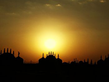 Silhouette buildings against sky during sunset
