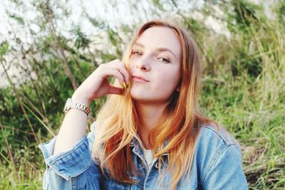 Portrait of beautiful young woman against plants