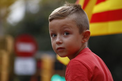 Portrait of cute boy looking away outdoors