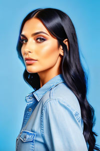 Portrait of young woman against blue background