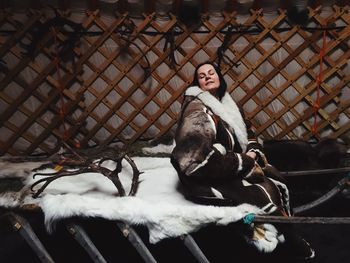 Woman with eyes closed sitting on fur