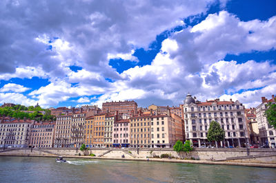 Buildings in city against cloudy sky