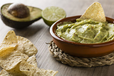 Tortilla chips with avocado on table