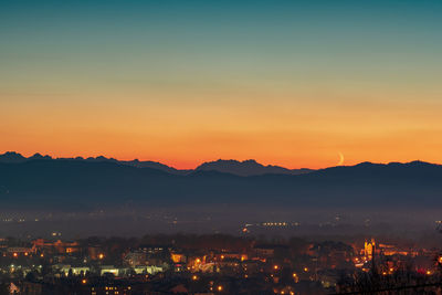 High angle view of illuminated cityscape against sky during sunset