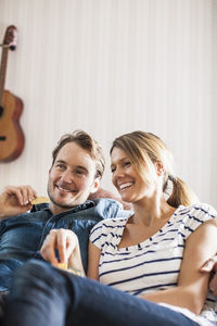 Happy couple having snacks while watching tv