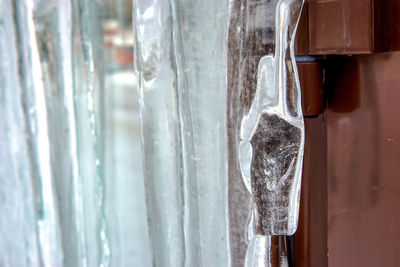 Close-up of icicles on glass door