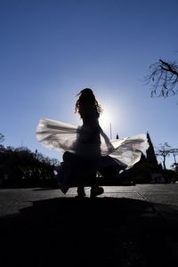 Woman with umbrella against sky