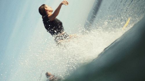 Low section of man swimming in sea