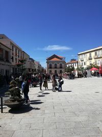 People on street against buildings in town