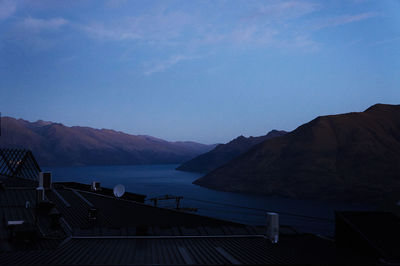 Scenic view of river and mountains against sky at dusk