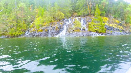 Scenic view of waterfall against sky