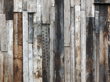 Rough textured timber wall made of stained mismatched recycled old planks