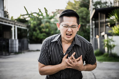 Man with heart attack standing outdoors