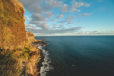 Sunset on atlantic coast off island of madeira, portugal. rocks illuminated with golden light