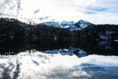 Scenic view of lake by snowcapped mountains against sky