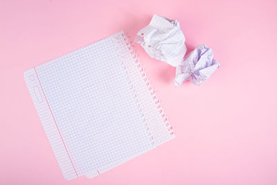 High angle view of paper currency against pink background