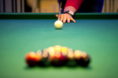 Cropped hand of man playing pool