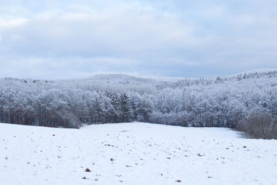 Scenic view of snow covered field against sky