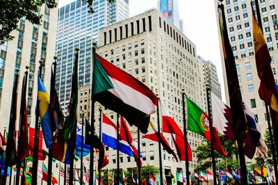 Low angle view of flags against buildings in city