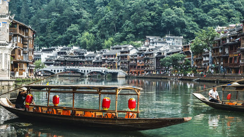 Boats sailing on river in city