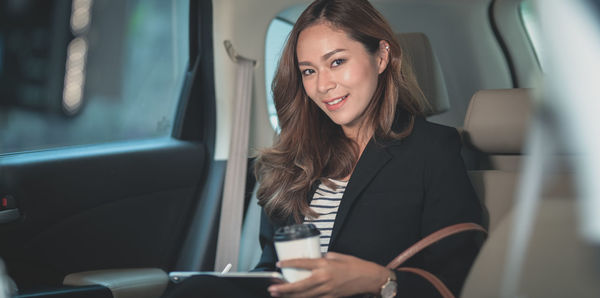 Portrait of smiling woman sitting in bus