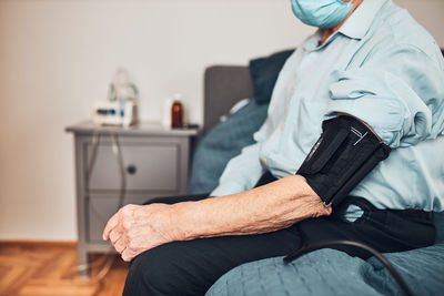 Senior man measuring blood pressure and heart rate himself. checking health condition