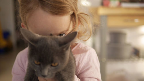 Portrait of girl with cat at home