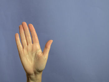 Close-up of hand against blue background